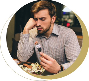 Man looking worried to eat food at a restaurant due to jaw pain