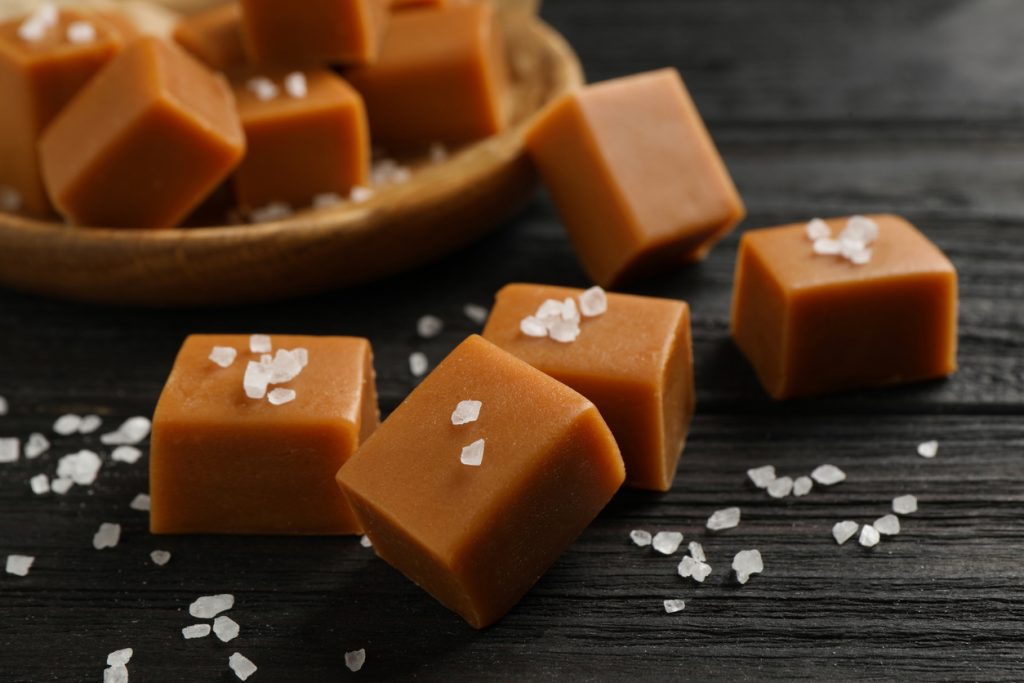 Chewy caramel cubes with sea salt on black  table top