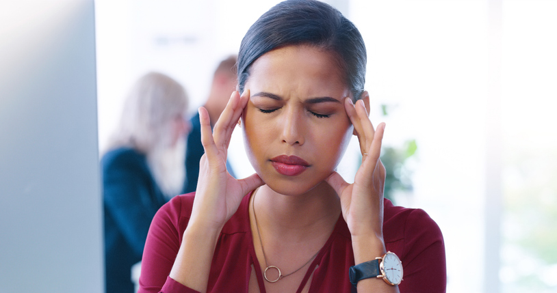 Young business women suffering from TMJ headaches.