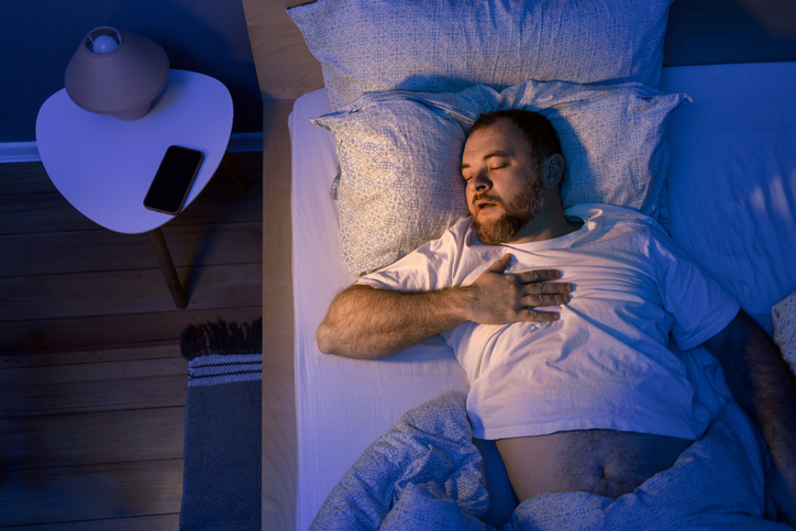 Man suffering with sleep apnea and acid reflux.
